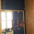 The new roller shutter is installed behind the front doors, and is tested in situ.