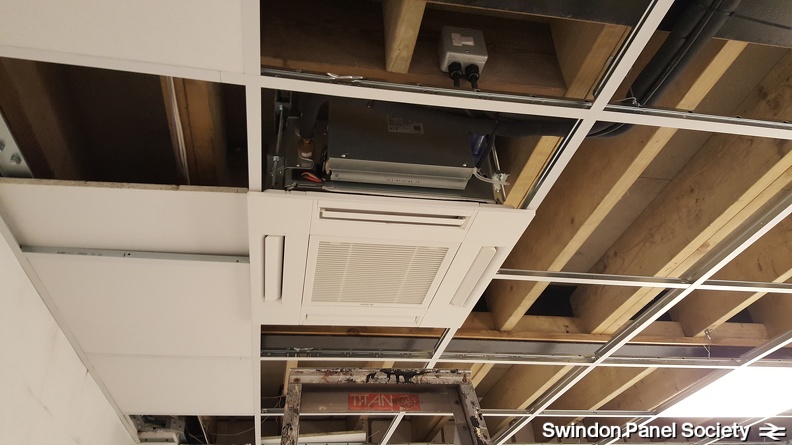 With the air-conditioning units in, surrounding ceiling tiles start to be installed, having been cut to size accordingly.