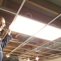 Let there be light! (1) - GWS electrician David Brown test fits the first LED fitment to the Panel Room suspended ceiling.