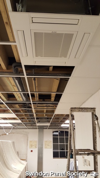 Ever more ceiling tiles become fitted in place, with the 1980s panel room atmosphere truly starting to take shape.